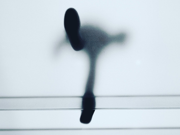Worm's eye view of a silhouetted person stepping forward